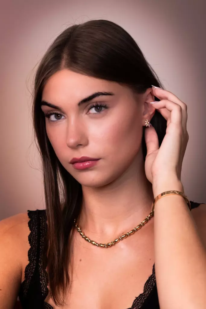 Portrait d'une femme portant un collier, un bracelet et une boucle d'oreille dorés