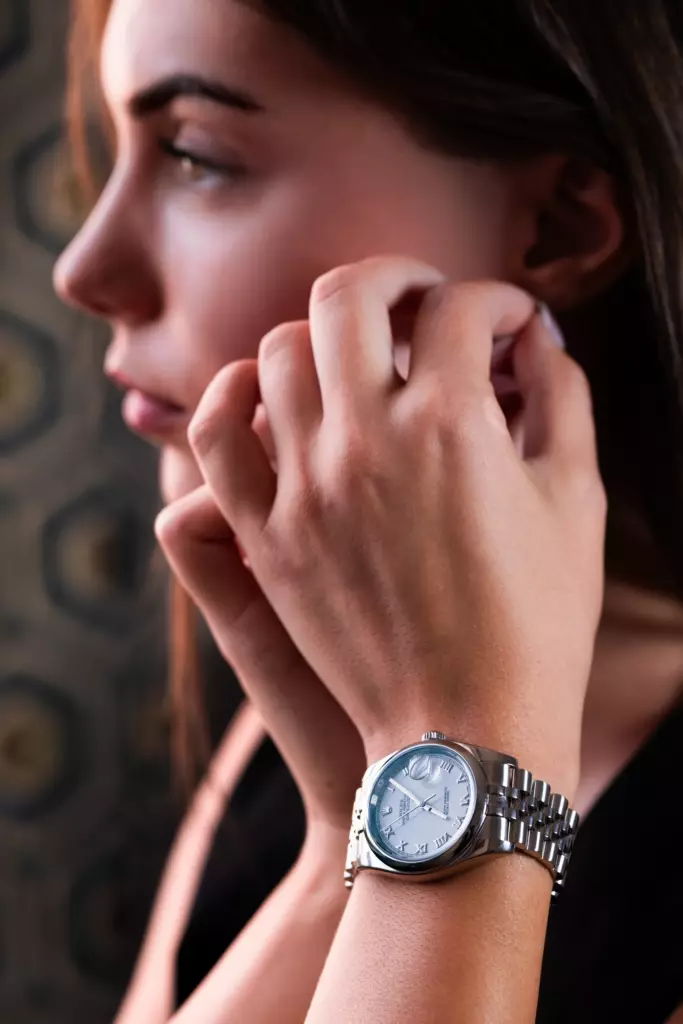 Femme de profil portant une montre en acier à cadran bleu