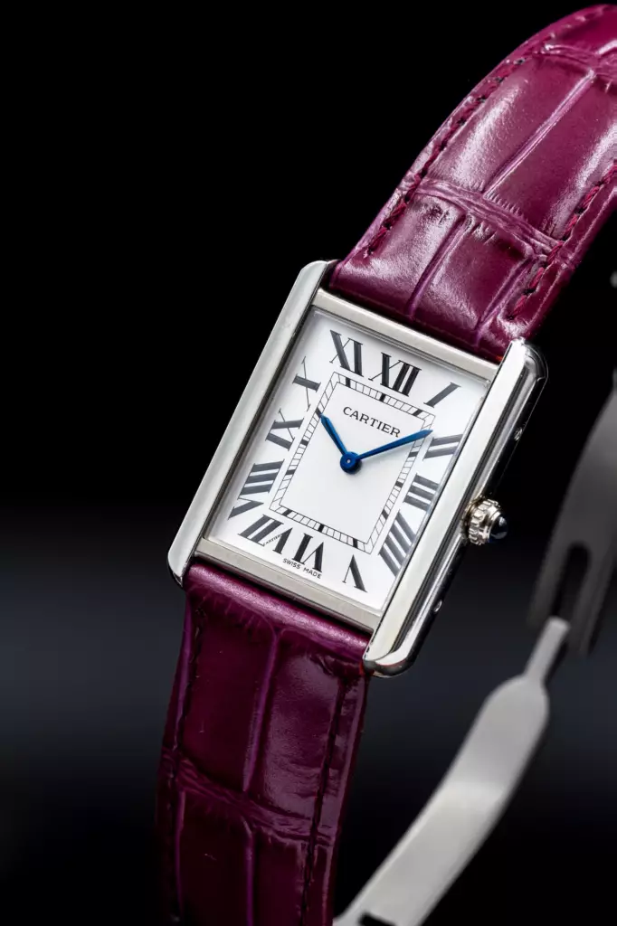 Montre Cartier Tank à bracelet en cuir bordeaux sur fond noir