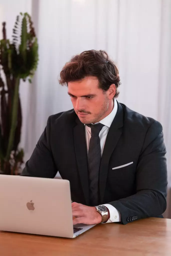 Portrait corporate d'un homme en costume travaillant sur son ordinateur portable