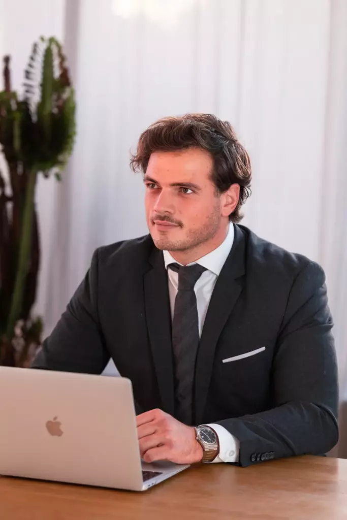 Portrait corporate d'un homme en costume assis à son bureau, regard de côté